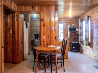 A table and chairs in a room with wood paneling.