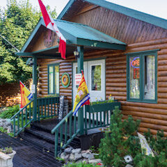 A log cabin with flags on the front porch.