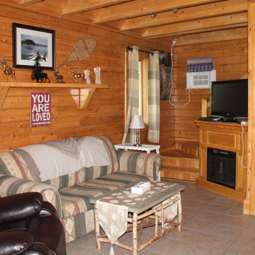 A living room with a couch, chair and television.