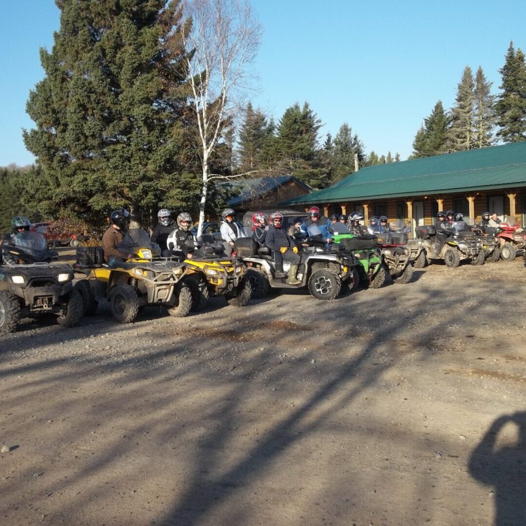 A group of people on atvs parked in front of a building.